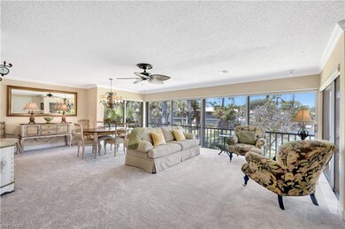 Carpeted living room featuring crown molding, a te