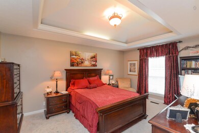 Large master suite with attached bathroom has lighted tray ceilings, attached bathroom with custom built, tall vanity with pull-out draws and large garden tub.