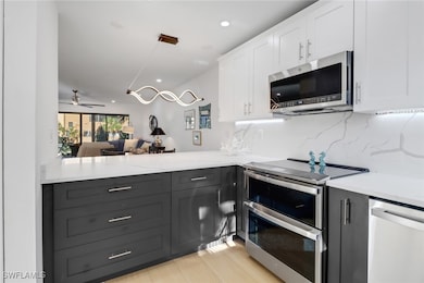 Kitchen with backsplash, white cabinets, a peninsu