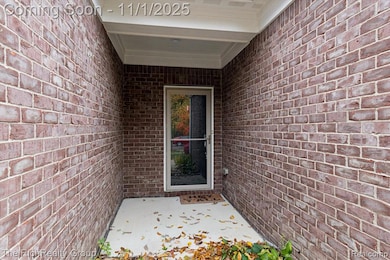 Property entrance with brick siding and a patio