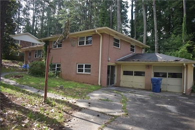 View of side of home with brick siding, asphalt driveway, and an attached garage