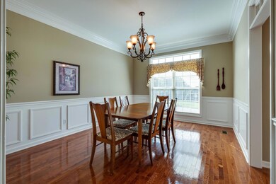 This formal dining room has wainscoting, crown molding and wood floors@ 