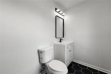 Bathroom with toilet, vanity, tile patterned floors, and baseboards