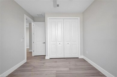 Unfurnished bedroom with visible vents, light wood