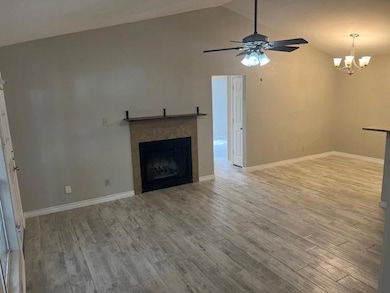 Unfurnished living room featuring a chandelier, c