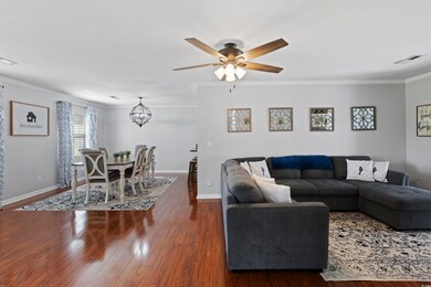 Living area featuring ornamental molding, a chande