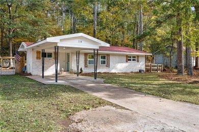 View of front of property featuring a front lawn, brick siding, and concrete driveway