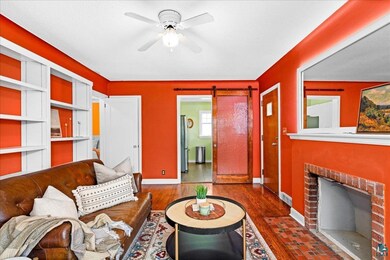 Living room featuring baseboards, a barn door, vis