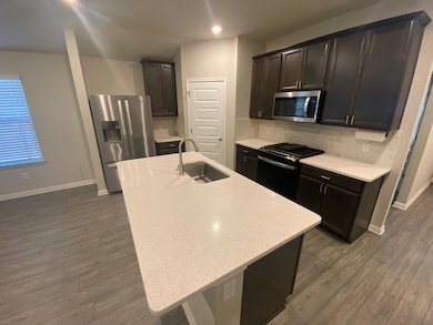Kitchen featuring light stone counters, stainless