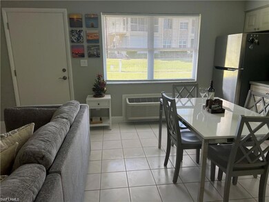 Tiled dining space featuring a wall mounted AC and