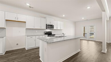 Kitchen featuring ornamental molding, white cabinets, backsplash, light stone counters, and dark wood-style flooring
