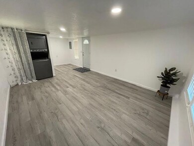 Unfurnished living room featuring wood finished floors and baseboards