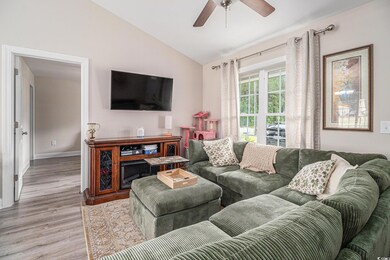 Living room featuring wood finished floors, vaulte