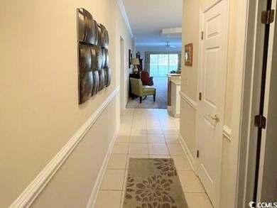 Hall with ornamental molding and light tile patter