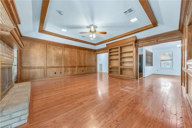 Unfurnished living room featuring ceiling fan, a r