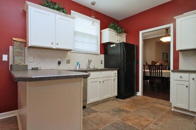 The kitchen features a tile floor and backsplash.