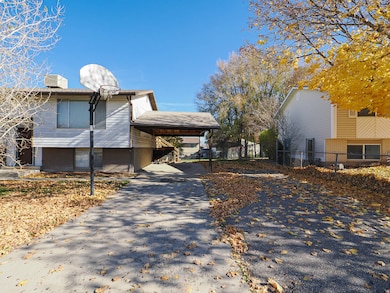 View of side of home with brick siding, asphalt driveway, an attached carport, and a chimney