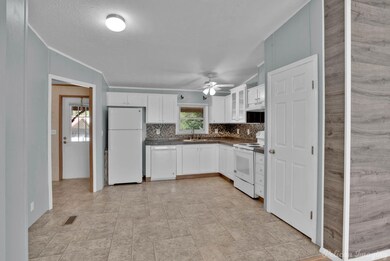 Kitchen featuring white appliances, backsplash, si