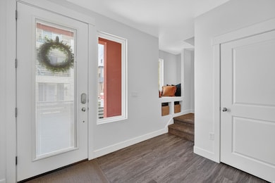 Entrance foyer with dark wood-style flooring and stairs