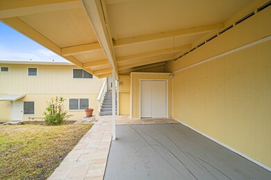 Carport in the front with an entrance to upstairs and one to downstairs