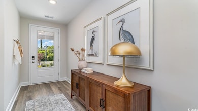 Doorway with wood finished floors, baseboards, and