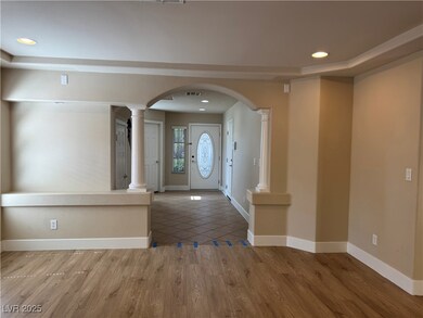 Foyer with ornate columns, wood finished floors, a