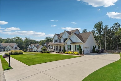 View of front of house featuring board and batten siding, a garage, concrete driveway, and a front yard