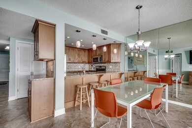 Dining area featuring a textured ceiling, a chandelier, and baseboards