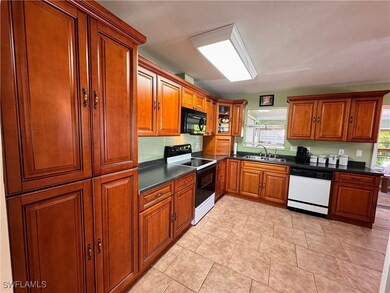 Kitchen with black microwave, range with electric