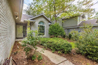 Entrance to property with brick siding and a shingled roof