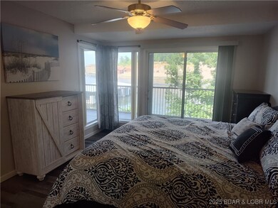 Primary bedroom with slider out to the deck and wide-open lake views