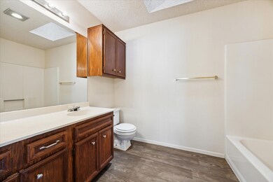 Full bathroom featuring a skylight, wood finished