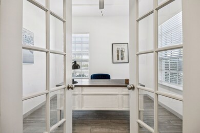 Office space with dark wood finished floors, plenty of natural light, and french doors