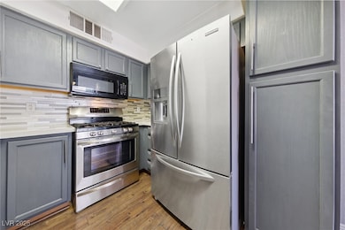 Kitchen with stainless steel appliances, gray cabi