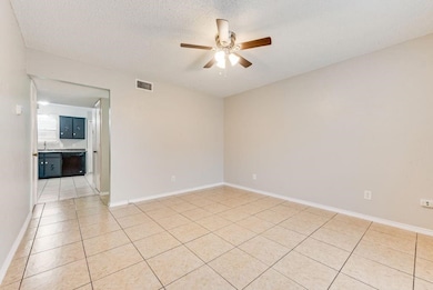Unfurnished room featuring light tile patterned floors, ceiling fan, and a textured ceiling