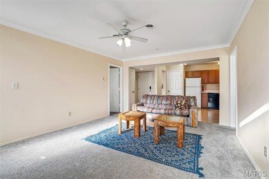 Dining space with ornamental molding, light carpet, and a ceiling fan