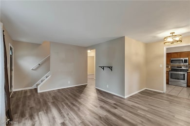 Unfurnished living room featuring light wood-style flooring and stairway