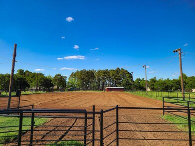 Featuring an enclosed horse arena and view of wooded area