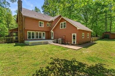 Back of property with a chimney, a storage shed, a