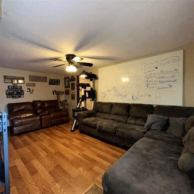 Living room with ceiling fan and hardwood / wood-s