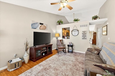 Living area featuring lofted ceiling, light wood finished floors, and ceiling fan