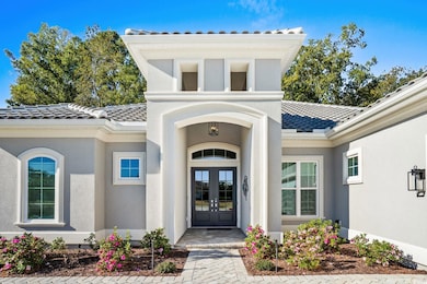 View of exterior entry with a tile roof, french doors, and stucco siding