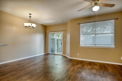 Empty room featuring wood finished floors, a ceiling fan, and a chandelier