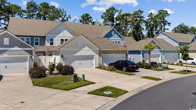 View of front of home featuring concrete driveway, roof with shingles, a gate, and a residential view