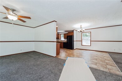Empty room featuring a chandelier, light carpet, b