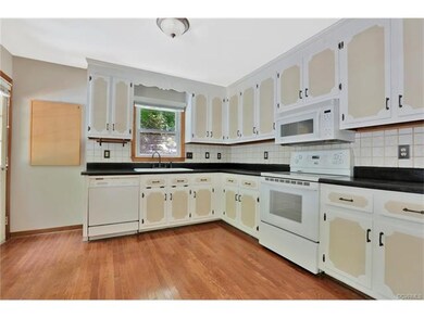 Spacious kitchen with wood floors, tile back splas