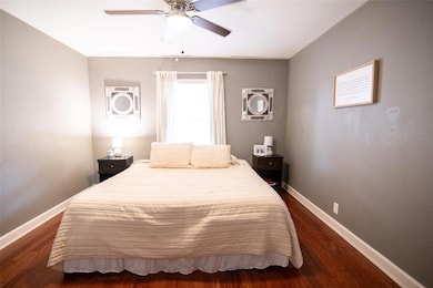 Bedroom featuring baseboards, dark wood-style flo