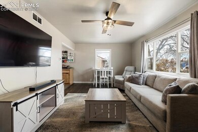 Living room with ceiling fan and dark hardwood / w