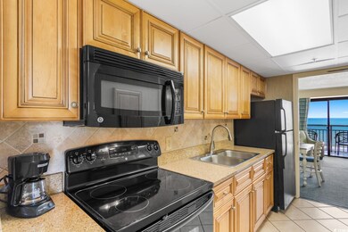 Kitchen with a water view, backsplash, black appli