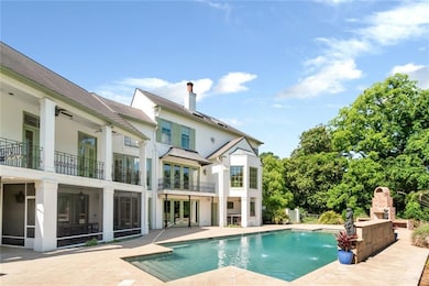 Back of house with a fireplace, a patio, a balcony